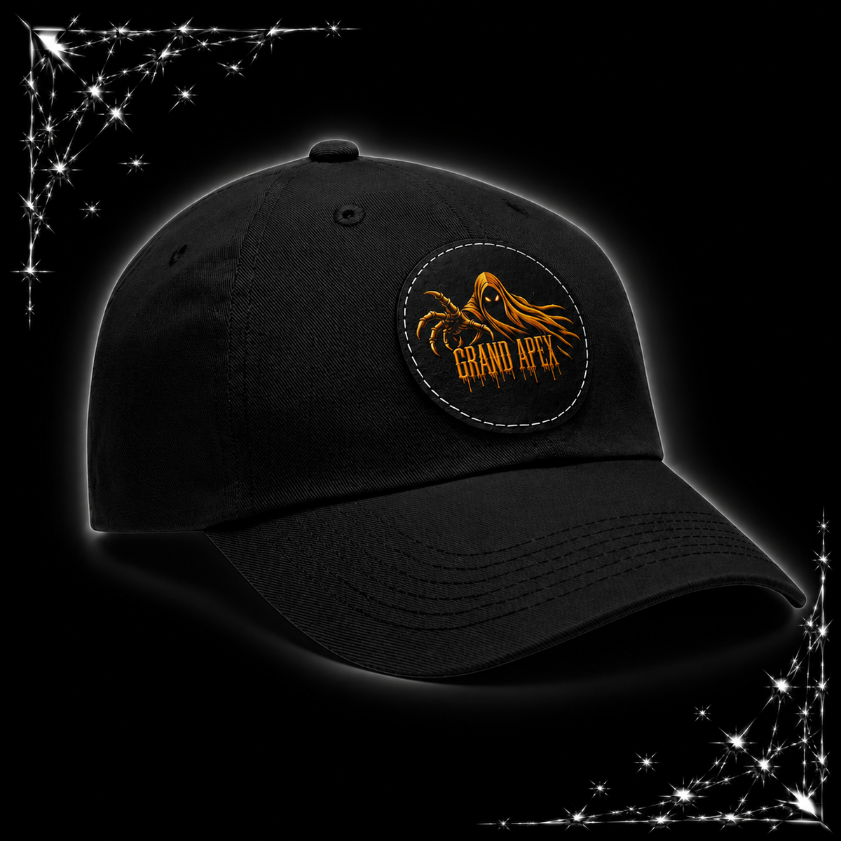 A black baseball cap with a circular embroidered patch on the front featuring an orange and yellow mountain graphic and the text 'GRAND APEX'. The cap is shown against a black background with chrome webbing corner accents.
