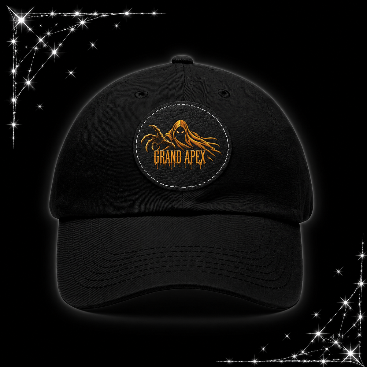 A black baseball cap featuring a circular embroidered patch on the front with a golden hooded figure and the text 'GRAND APEX'. The cap is displayed against a black background with chrome webbing graphics in the corners.