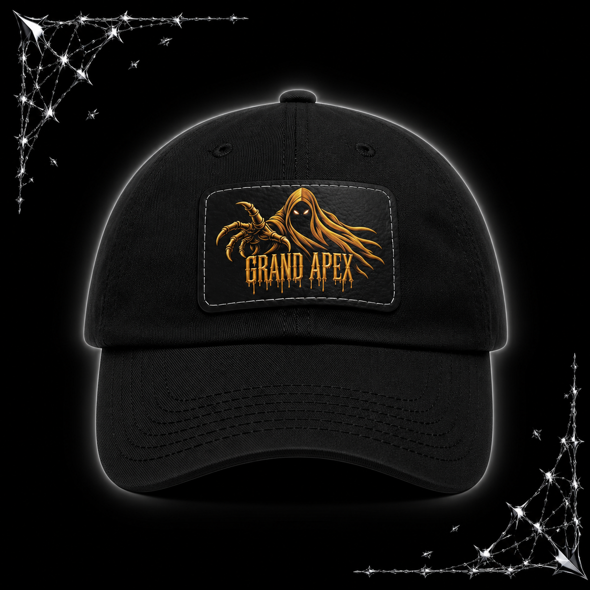 A black baseball cap with a rectangular front patch featuring a yellow-orange hooded ape graphic and the text 'GRAND APEX'. The cap is shown on a black background with chrome spiked webbing corner graphics.
